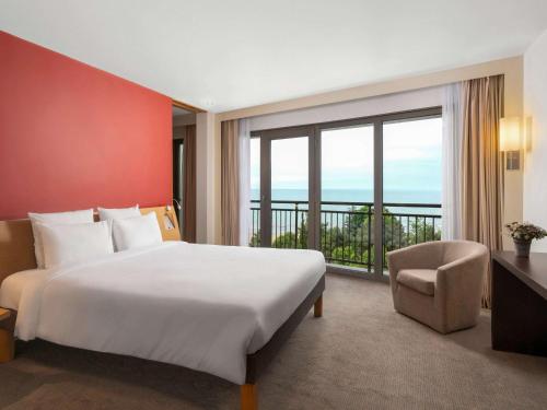 a bedroom with a large bed and a large window at Novotel Trabzon in Trabzon