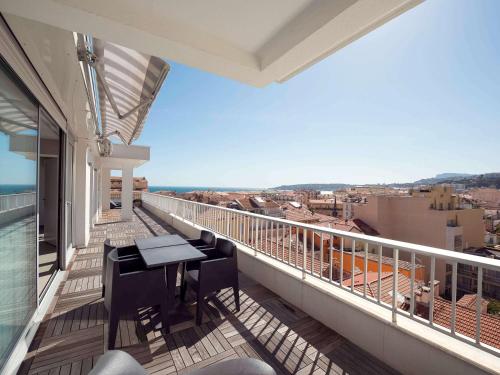 a balcony with a table and a view of the city at Ibis Styles Menton Centre in Menton