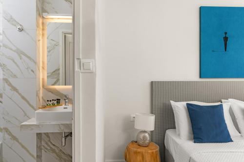 een slaapkamer met een bed met een wastafel en een spiegel bij Paradise Art Hotel in Ándros