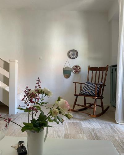 a room with a chair and a vase with flowers on a table at Kővirág Panzió in Köveskál