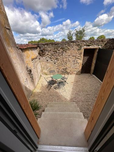 a stone building with stairs and a table and chairs at Les Remparts in Langres