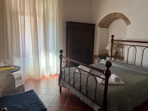 a bedroom with a bed and a table and a window at A La Casa Dei Potenti in San Gimignano