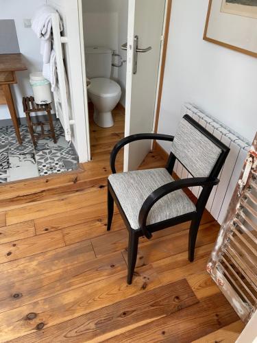 BazenvilleにあるÔ LOFTのバスルーム(トイレ付)に黒い椅子が備わります。