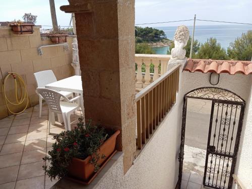 a balcony with a gate and a table and chairs at casa dolce casa in Patù