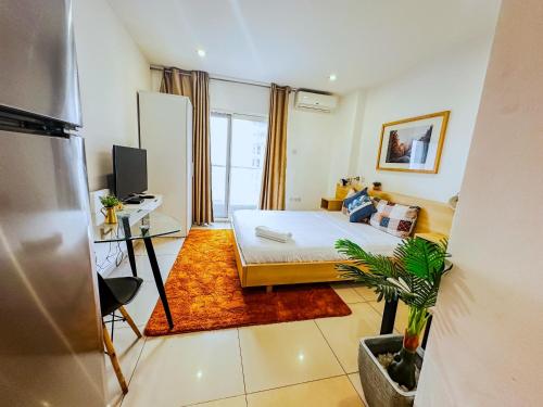 a small room with a bed and a tv at Gallery Apartments by BestWest Hospitality in Accra