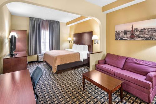 a hotel room with a bed and a couch at Clarion Inn & Suites Northwest in Indianapolis