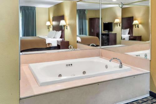 un baño grande con bañera en una habitación de hotel en Clarion Inn & Suites Northwest, en Indianápolis