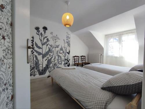 une chambre avec deux lits et une fenêtre dans l'établissement Gîte Saint-Denis - proche centre ville - jardin, à Châteauroux