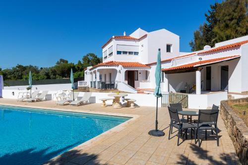 a villa with a swimming pool and a house at Apartamentos - Solar Vale Covo in Carvoeiro