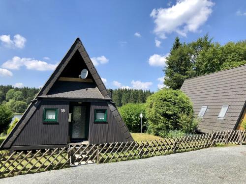 una pequeña casa con techo de gambrel en Holiday home in Clausthal Zellerfeld with garden furniture, en Clausthal-Zellerfeld