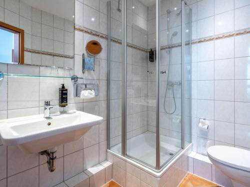 ein Bad mit einer Dusche, einem Waschbecken und einem WC in der Unterkunft Mercure Hotel Luebeck City Center in Lübeck