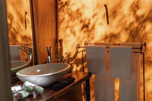 a bathroom with two sinks and two mirrors at Umkumbe Bush Lodge - Luxury Tented Camp in Sabi Sand Game Reserve