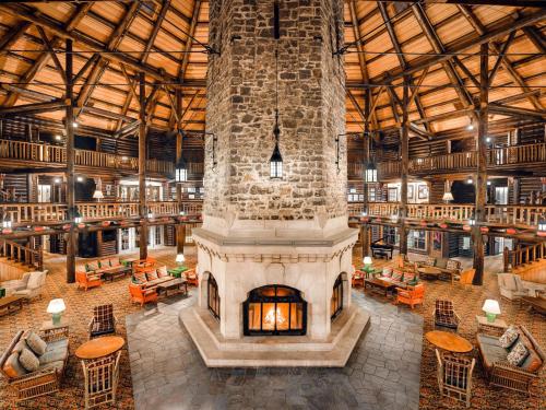 a large room with a large stone fireplace in a library at Fairmont Le Chateau Montebello in Montebello