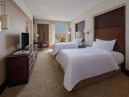um quarto de hotel com duas camas e uma televisão em Makkah Clock Royal Tower, A Fairmont Hotel em Meca