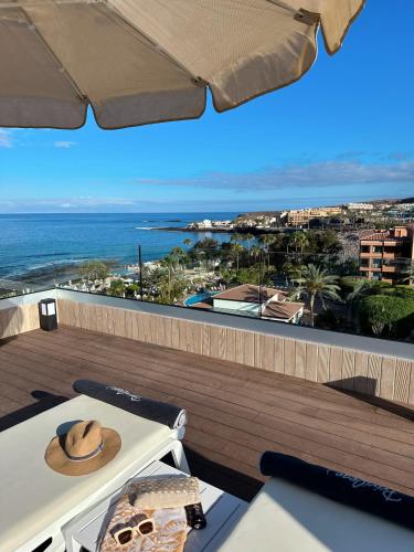 a table with a hat on a balcony with the ocean at H10 Costa Adeje Palace in Adeje