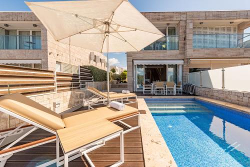 a pool with chairs and an umbrella next to a house at Villa Lantana ZadarVillas in Petrcane