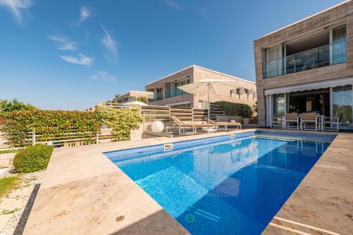 a swimming pool in front of a house at Villa Lantana ZadarVillas in Petrcane