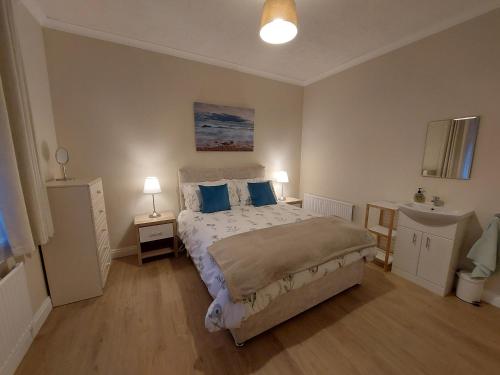 a bedroom with a large bed with blue pillows at Seaview Cottage Dugort Achill Island in Doogort