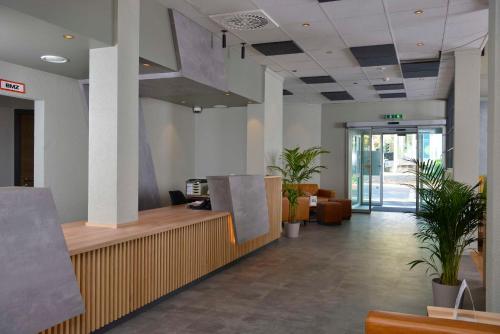 an office lobby with potted plants and a reception desk at Sure Hotel by Best Western Hilden-Düsseldorf in Hilden
