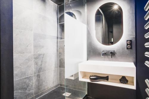 une salle de bain avec un lavabo et un miroir dans l'établissement Blue King Suite - Triangle d'Or, à Villeurbanne