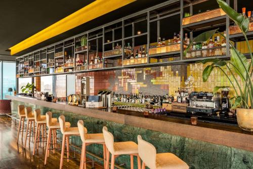 a bar with a bunch of chairs and a counter at Vienna House by Wyndham Andel's Berlin in Berlin