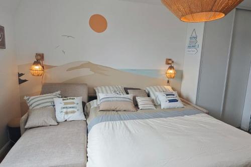 ein Schlafzimmer mit einem großen Bett mit Kissen darauf in der Unterkunft BERCK Beach Attitude 160 QUEEN SIZE très confort - 3min de la plage in Berck-sur-Mer