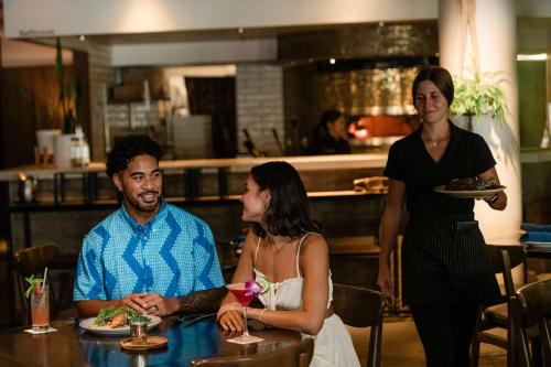 a group of people sitting at a table in a restaurant at OUTRIGGER Waikiki Paradise Hotel in Honolulu