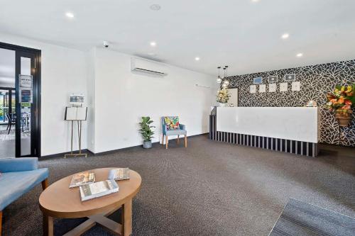 a living room with a couch and a table at Quality Resort Parkhurst in Rockhampton