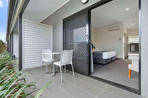 a bedroom with a bed and a table and chairs at Quality Resort Parkhurst in Rockhampton