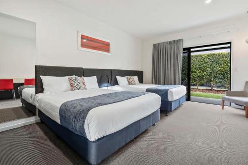 Habitación de hotel con 2 camas y ventana en Quality Resort Parkhurst en Rockhampton