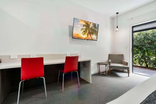 a waiting room with two red chairs and a desk at Quality Resort Parkhurst in Rockhampton