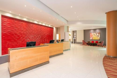 un vestíbulo de un hotel con una pared roja en London Twickenham Stadium Hotel, a member of Radisson Individuals en Twickenham