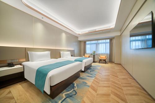 une chambre d'hôtel avec un grand lit et une fenêtre dans l'établissement Hangzhou Canal Seagull Hotel, à Hangzhou