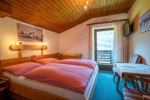 a bedroom with two beds and a window at Mittereggalm in Mühlbach am Hochkönig