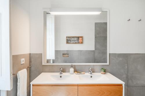 a bathroom with a sink and a mirror at VIVA Boavista Vintage House in Porto
