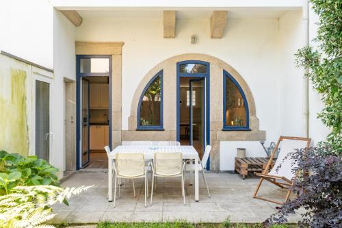 a white table and chairs on a patio at VIVA Boavista Vintage House in Porto