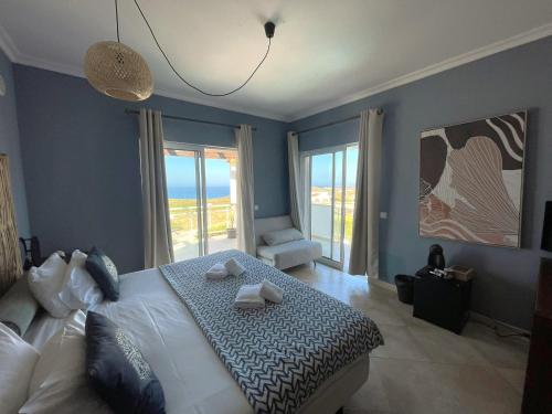 een slaapkamer met een bed met twee handdoeken erop bij Arrifana Destination Suites in Aljezur