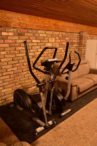 una bicicletta parcheggiata accanto a un muro di mattoni con un divano di Gyömbér Tanya a Ásotthalom