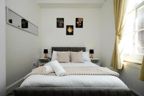 Un dormitorio con una cama con paredes blancas y una ventana en Islington Hideout en Londres