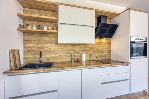a kitchen with white cabinets and a sink at Villa Hill with Private Pool in Bosanska Krupa