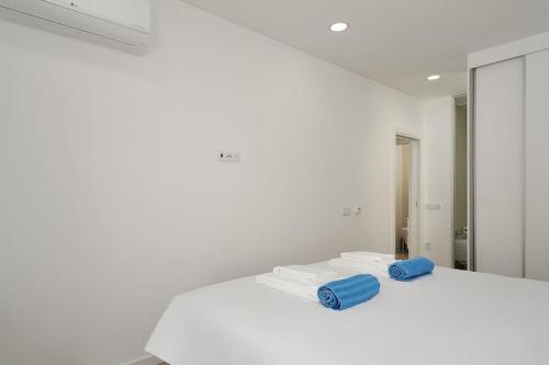 a white room with two towels and a mirror at Dália modern apartment Five minutes to beach in Luz