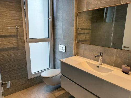 a bathroom with a sink and a toilet and a mirror at Prince Palace Netanya Central Beach in Netanya