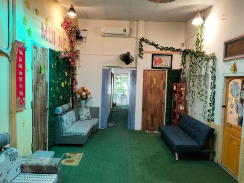a living room with couches and a green carpet at BONNIE HOMESTAY Mui Ne in Mui Ne