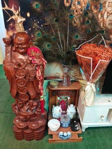 a statue of a buddha standing next to a table at BONNIE HOMESTAY Mui Ne in Mui Ne