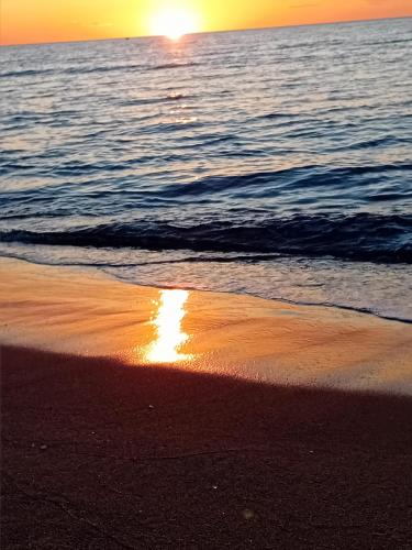 a sunset on the beach with the sun reflecting on the sand at Duplex de 40m2 avec piscine à Canet en Roussillon in Canet-en-Roussillon