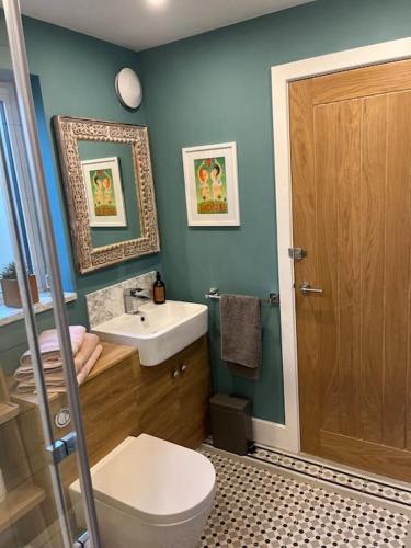 a bathroom with a toilet and a sink at Cotswold Retreat in Cheltenham