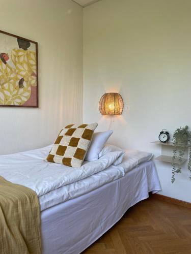 a bedroom with a white bed with a lamp on it at Ewa & Maude Hotel in Gothenburg