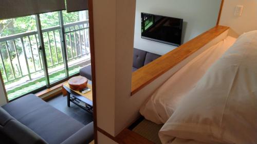 a room with a bedroom with a bed and a tv at 御宿しんしま in Matsuzaki