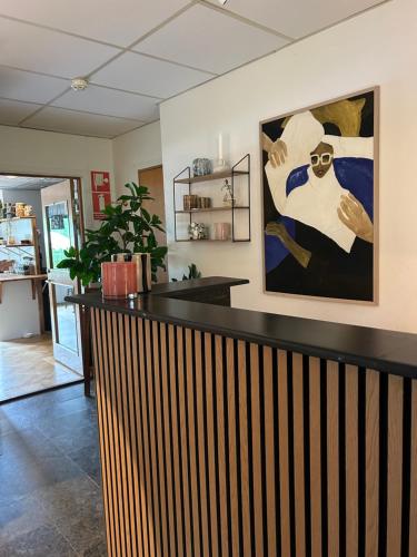 a bar in a room with a painting on the wall at Ewa & Maude Hotel in Gothenburg