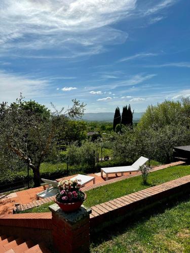a garden with a bench and a vase of flowers at Il Villino del Daino - Toscana in Loro Ciuffenna